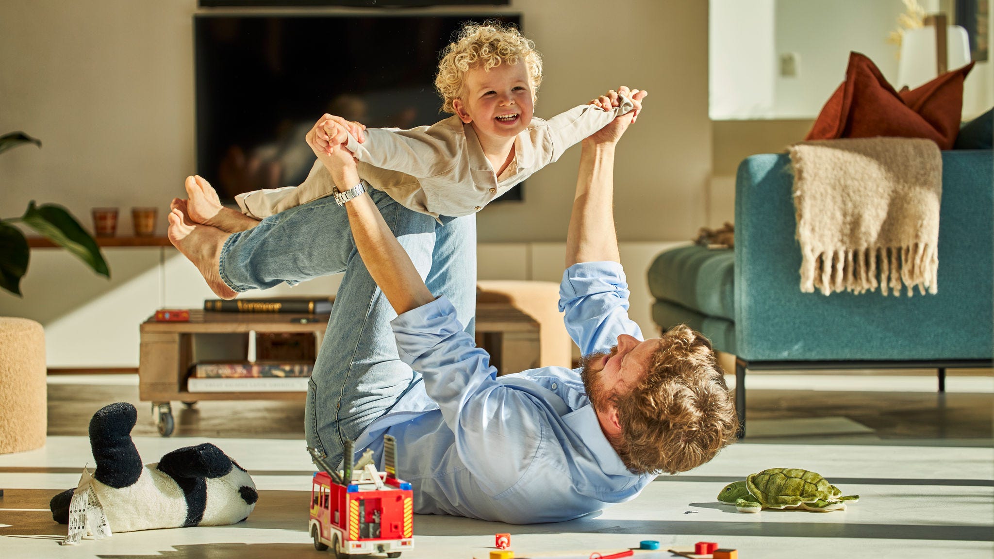 Pai e filho a brincar alegremente e a usufruir do conforto do piso radiante