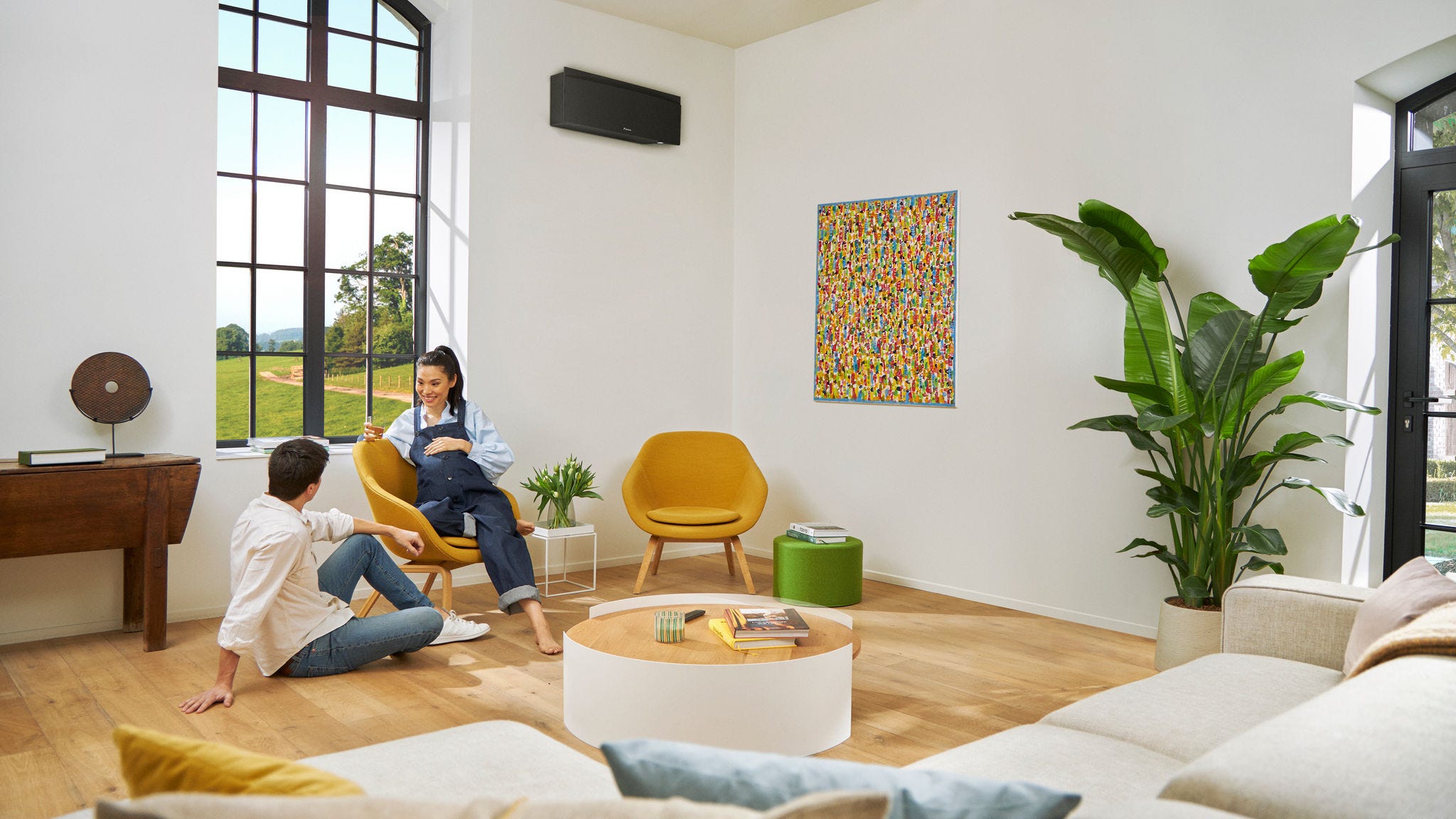 Casal de futuros pais a conversar enquanto a mulher está sentada numa cadeira