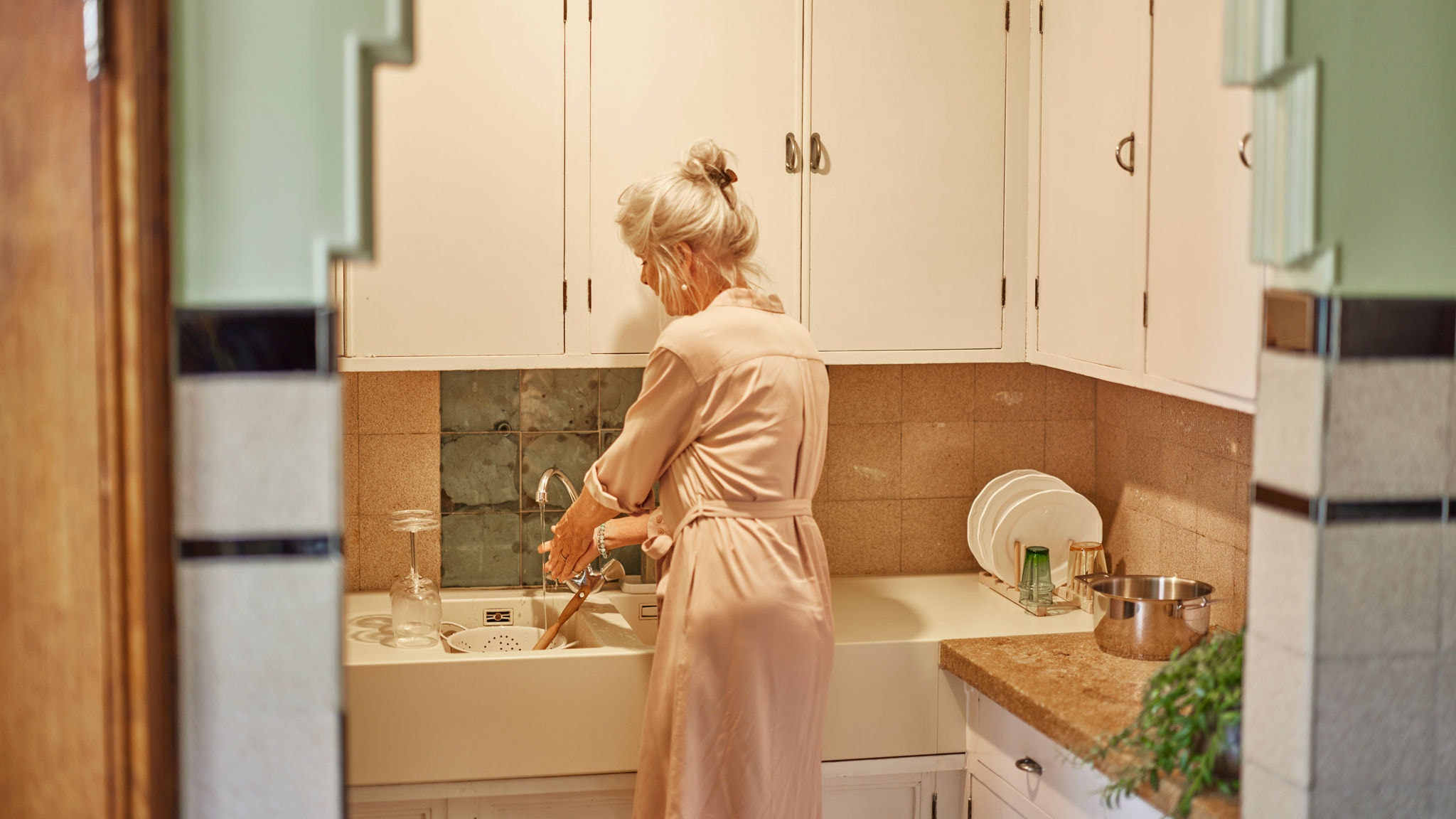 Mulher a lavar a loiça com água quente graças ao sistema Multi Split