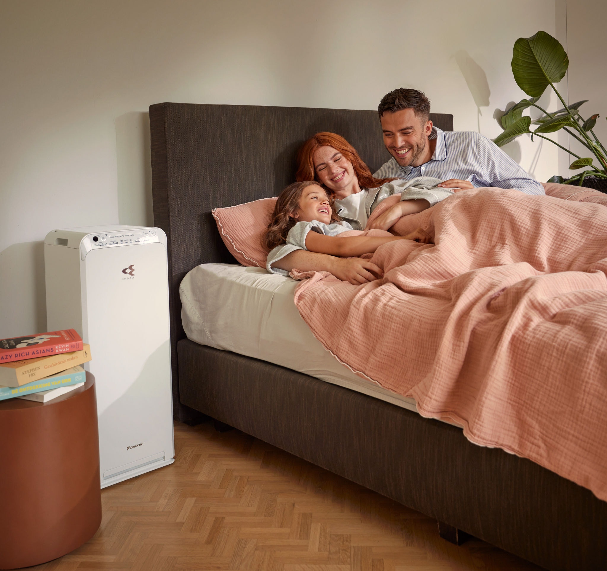 Casal com criança a relaxar no quarto e a usufruir de ar limpo graças ao purificador de ar