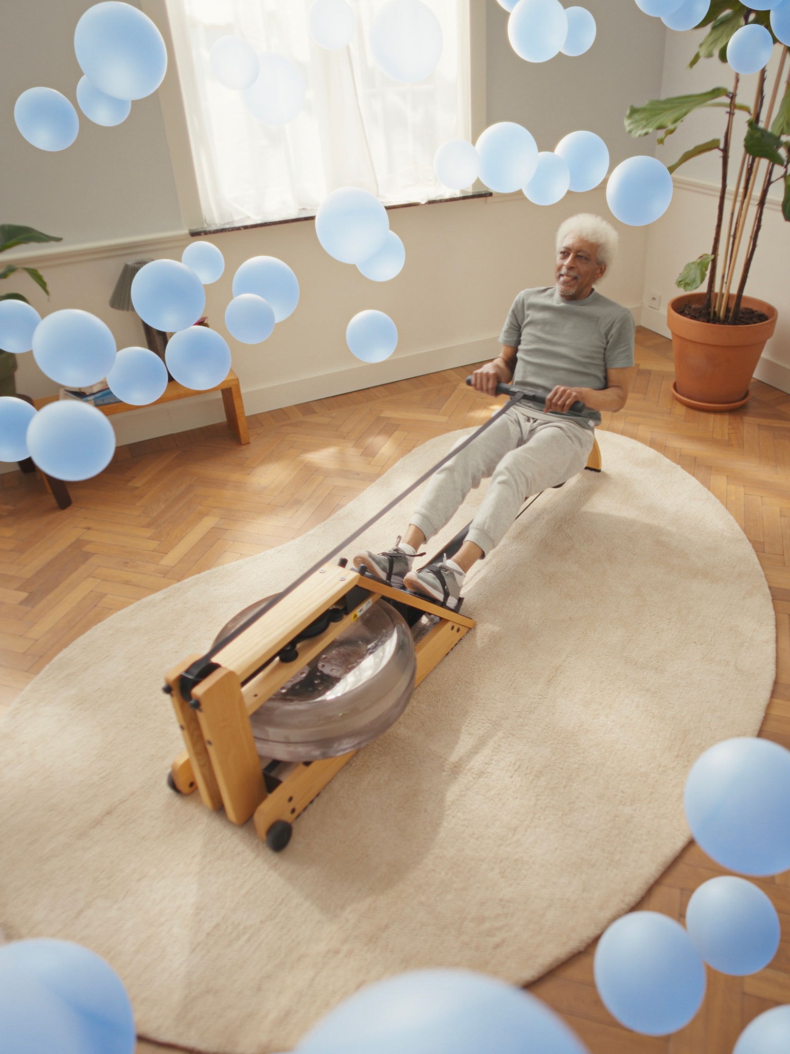 Homem mais velho a exercitar-se numa máquina de remo numa sala perfeitamente climatizada, graças à tecnologia de bomba de calor ar-ar de resposta rápida