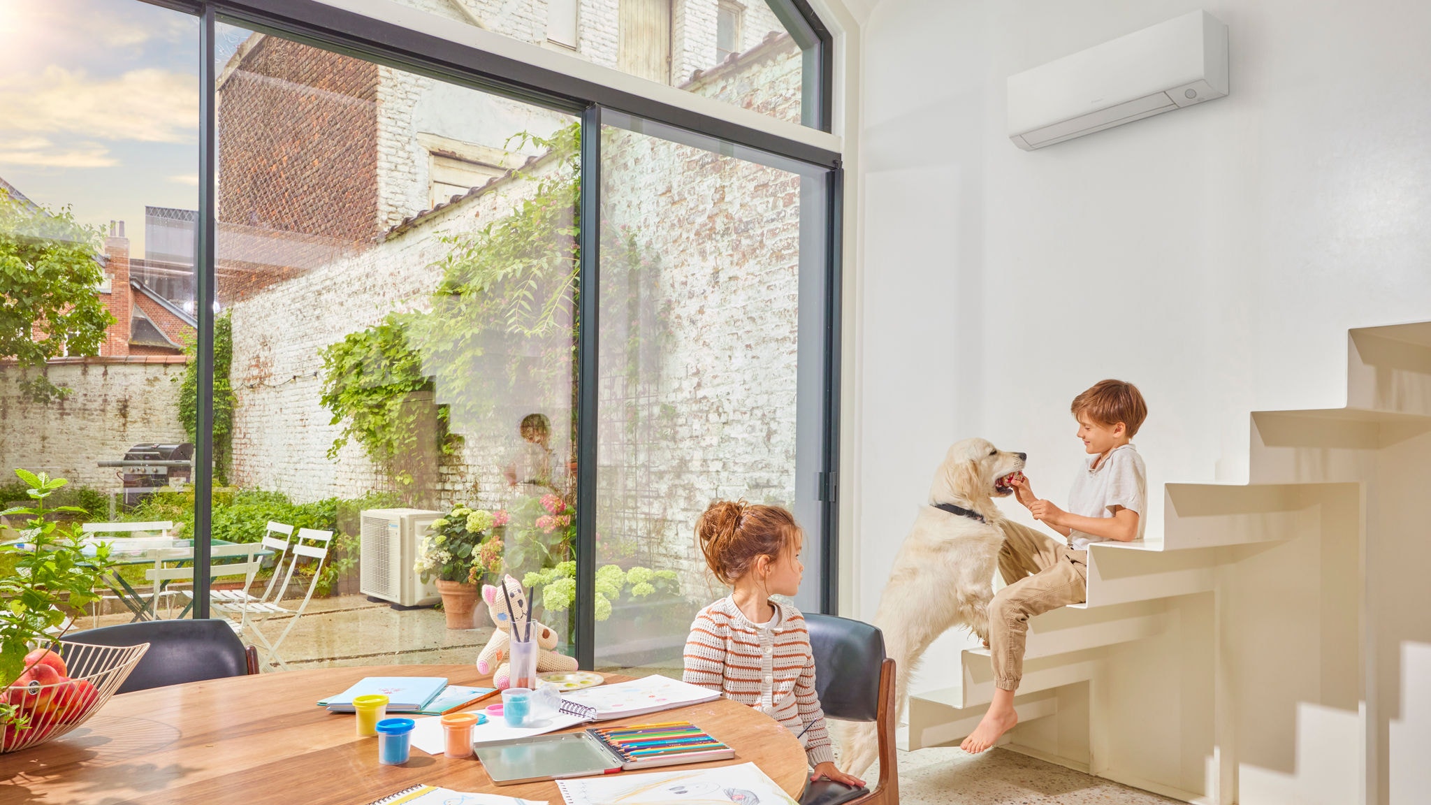Crianças e cachorro numa numa sala climatizada com Daikin